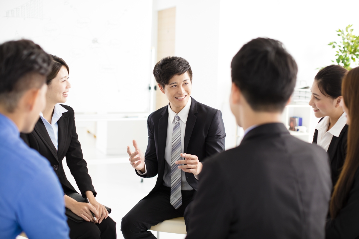 輪になって話す会社員